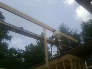 Carpenter setting a ridge beam over a new addition frame — Ice Dam Removal by Roofing Brothers in Macon