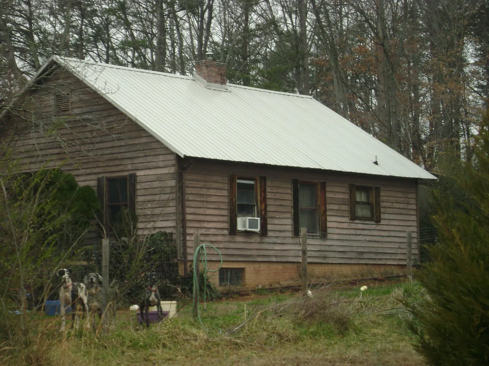 White metal roof on an old wood sided farmhouse, from a Metal Roof Installation job in Macon